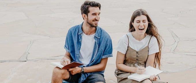two people holding books and flirting