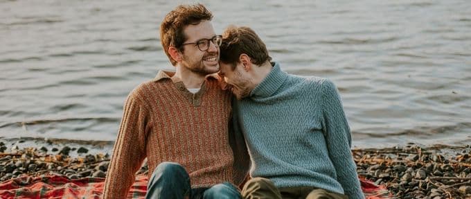 gay couple on beach smiling