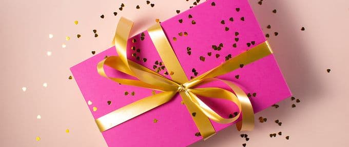 a valentine's day gift wrapped in a pink box and gold ribbon